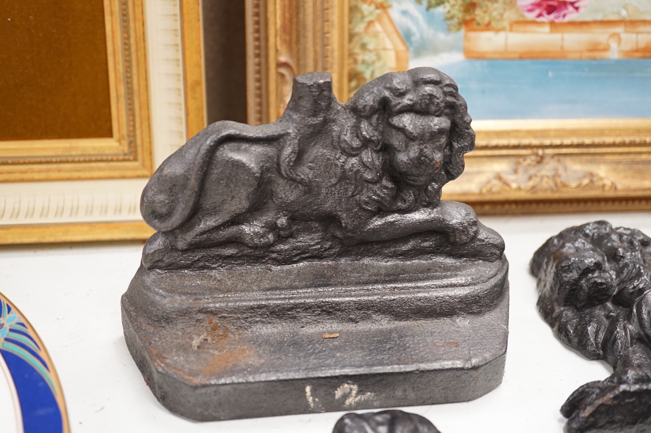 Two lion cast iron door stops, a St Bernard door stop and another, largest St Bernard 18cms high